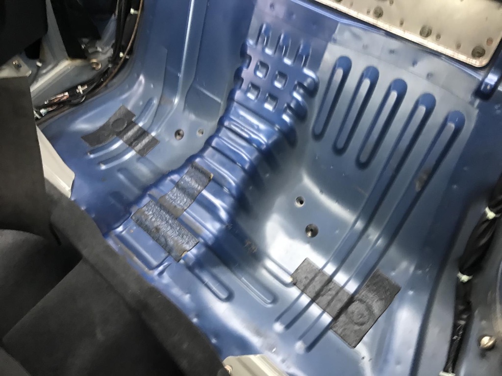 Exposed original Bayside Blue factory paint on the R34 GT-R floor pan and inner body shell with the interior stripped out.